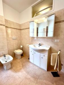 a bathroom with a sink and a toilet and a mirror at Appartamento alle Terrazze in Venice-Lido +26 photos