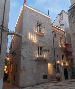 un edificio de piedra con 2 balcones en una calle en HolidayMonopoli en Monopoli