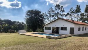 Quadra的住宿－Sítio São Luiz, R2: Refúgio rústico na Natureza，庭院中带游泳池的房子