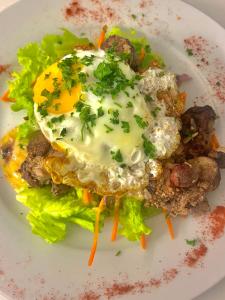 a plate of food with an egg on top of lettuce at Hôtel Restaurant Douce France in Saint Alban Auriolles