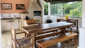 uma cozinha com uma mesa e cadeiras e uma lareira em Sítio São Luiz, R3: Aconchego rústico na natureza em Quadra