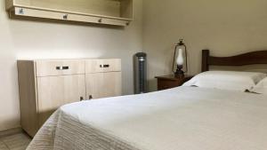 a bedroom with a large white bed and a lamp at Casa de Campo com Piscina e Churrasqueira in Quadra +59 photos