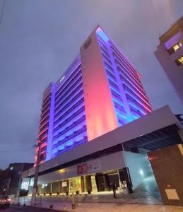 un grande edificio con luci blu e rosse di RN STUDIOs PREMIUM a Maceió