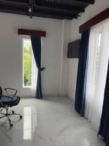 Habitación con cortinas azules, silla y ventana en Hermosa casa entre las Montañas- piso 2 en Birrí
