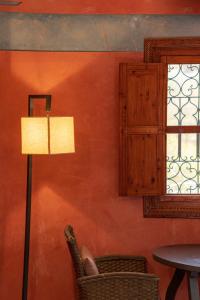 une lampe dans une chambre avec une chaise et une fenêtre dans l'établissement Riad Tourtit, à Imlil