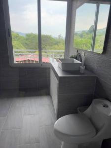 baño con aseo y lavabo y ventana en Hermosa casa entre las Montañas- piso 2 en Birrí