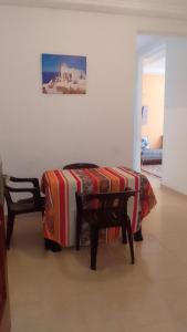 a room with a bed with a table and two chairs at Appartement valfleuri1 in Tangier