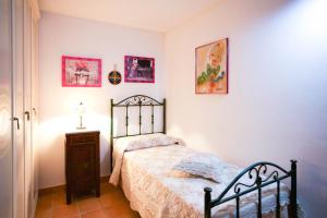 a bedroom with a bed and a table and pictures at Villa Pedra Moro in Alghero