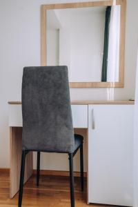 a chair sits in front of a desk with a mirror at Darki Apartments 2 - Very Central Stay With Free Parking in Ohrid