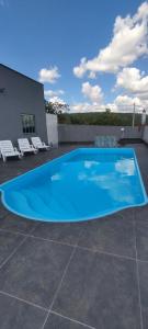 een groot blauw zwembad op een patio bij Rancho Léo Artes in Três Marias