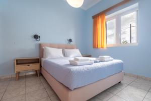 a bedroom with a bed with two towels on it at Tropical Beach "Poseidon" in Petalidi