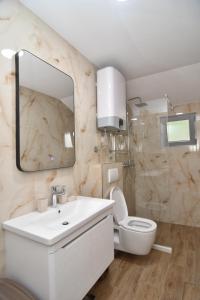 W łazience znajduje się umywalka, toaleta i lustro. w obiekcie Apartments Šišević w Budvie