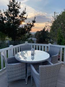 a table and chairs on a deck with a table and a tree at Rockley Valley TV36 in Lytchett Minster