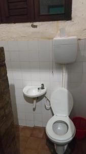 a bathroom with a toilet and a sink at Casa de praia Vera in Caucaia