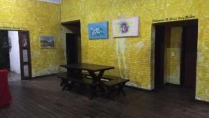 um quarto com uma mesa e uma parede amarela em Casa de praia Vera em Caucaia