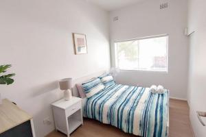 una camera bianca con un letto e una finestra di 3br house, 5 min walk to beach with parking a Sydney