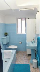un bagno blu con vasca e lavandino di 3br house, 5 min walk to beach with parking a Sydney