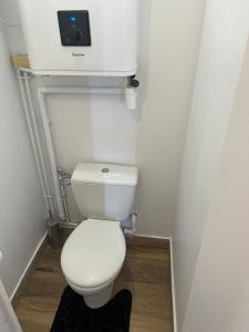 un piccolo bagno con servizi igienici e una telecamera sul muro di Appartement 2 pièces à Cabourg a Cabourg