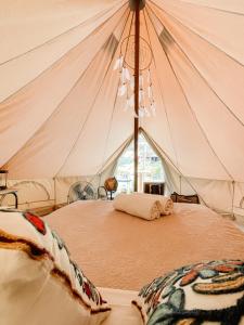- une chambre avec un lit dans une tente dans l'établissement Glamping Guayaha, à Lanquín