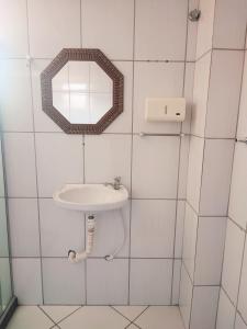 a bathroom with a sink and a mirror at Hotel Ita in Itaboraí