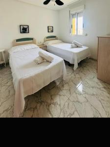 2 camas en una habitación con suelo de mármol en Apt Diego Long term stay, en Benidorm