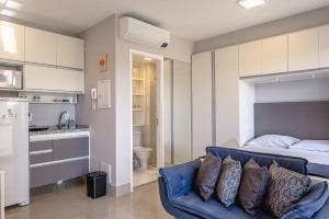 ein Wohnzimmer mit einer Couch und einem Bett in der Unterkunft Studio com garagem, ar condicionado e piscina in São Paulo