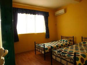 two beds in a room with a window at Sunny Villa in Dobrich
