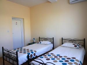 two beds sitting next to each other in a bedroom at Sunny Villa in Dobrich