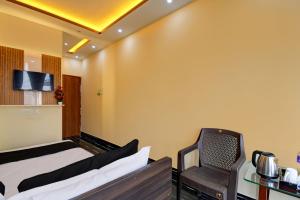 una camera d'albergo con due letti e una sedia di OYO Chilli Pepper Hotel and Restaurant a kolkata