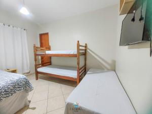 een slaapkamer met een bed en een wieg erin bij Pousada Catarina in Biguaçu
