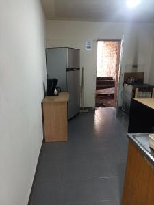 cocina con nevera, barra y puerta en Uziel en Humahuaca