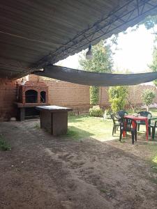 un patio con mesa y sillas y un edificio de ladrillo en Uziel en Humahuaca