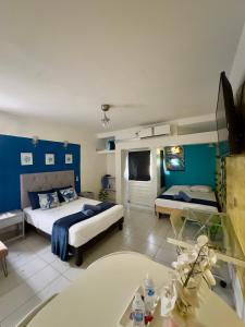 een slaapkamer met 2 bedden en een blauwe muur bij Suites Brisa Marina - Playa Regatas y Malecón in Veracruz