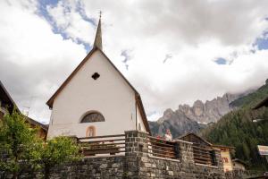 a church with a steeple on a stone wall at Chalet Le Grazie in Le Grazie