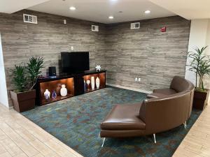 a waiting room with a couch and a television at Candlewood Suites LAX Hawthorne, an IHG Hotel in Hawthorne