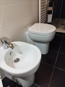 a bathroom with a white toilet and a bidet at La taverna sotto la torre in Massa Marittima