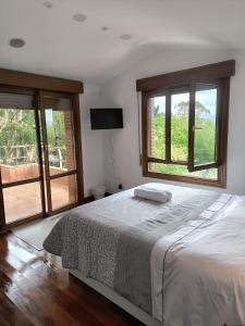 a bedroom with a bed and two windows at HABITACION CON HERMOSAS VISTAS A BILBAO in Bilbao