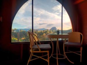 un tavolo e sedie di fronte a una grande finestra di Glamping The Mountain a Guatapé