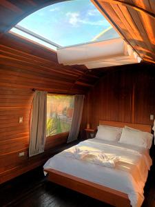 um quarto com uma cama grande e uma janela em Glamping The Mountain em Guatapé