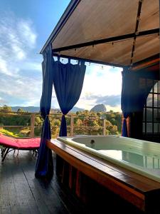 a bath tub on a deck with a view at Glamping The Mountain in Guatapé