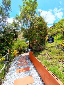 a stone walkway with a sign on the side of a house at Glamping The Mountain in Guatapé