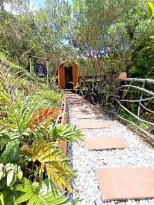 un jardín con un camino con plantas y una valla en Glamping The Mountain en Guatapé