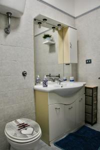 a bathroom with a sink and a toilet and a mirror at 4four Apartment 6-7 pax in Vitinia