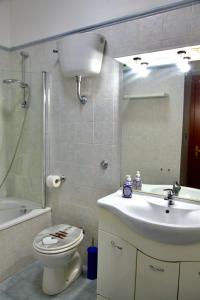 a bathroom with a toilet and a sink and a mirror at 4four Apartment 6-7 pax in Vitinia
