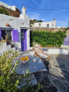 a table with a bowl of fruit on a patio at Sifnos Twin Houses in Apollonia