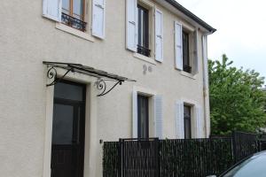 un bâtiment avec une porte noire et une clôture dans l'établissement L'Embellie, à Aix-les-Bains
