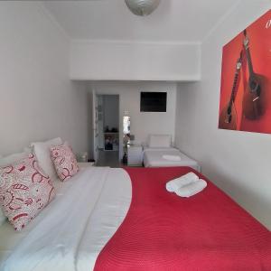 a bedroom with a large white bed with a red blanket at Divine House of Graça in Lisbon