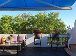 d'une terrasse avec une table et deux chaises sur un balcon. dans l'établissement AS CEGONHAS - ALOJAMENTo LOCAL, à Olhão