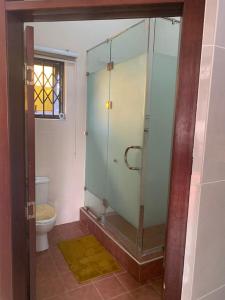 Golf Nest في آكرا: حمام مع دش زجاجي مع مرحاض