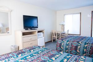 Habitación de hotel con cama y TV de pantalla plana. en Starlite Motel en Wisconsin Dells